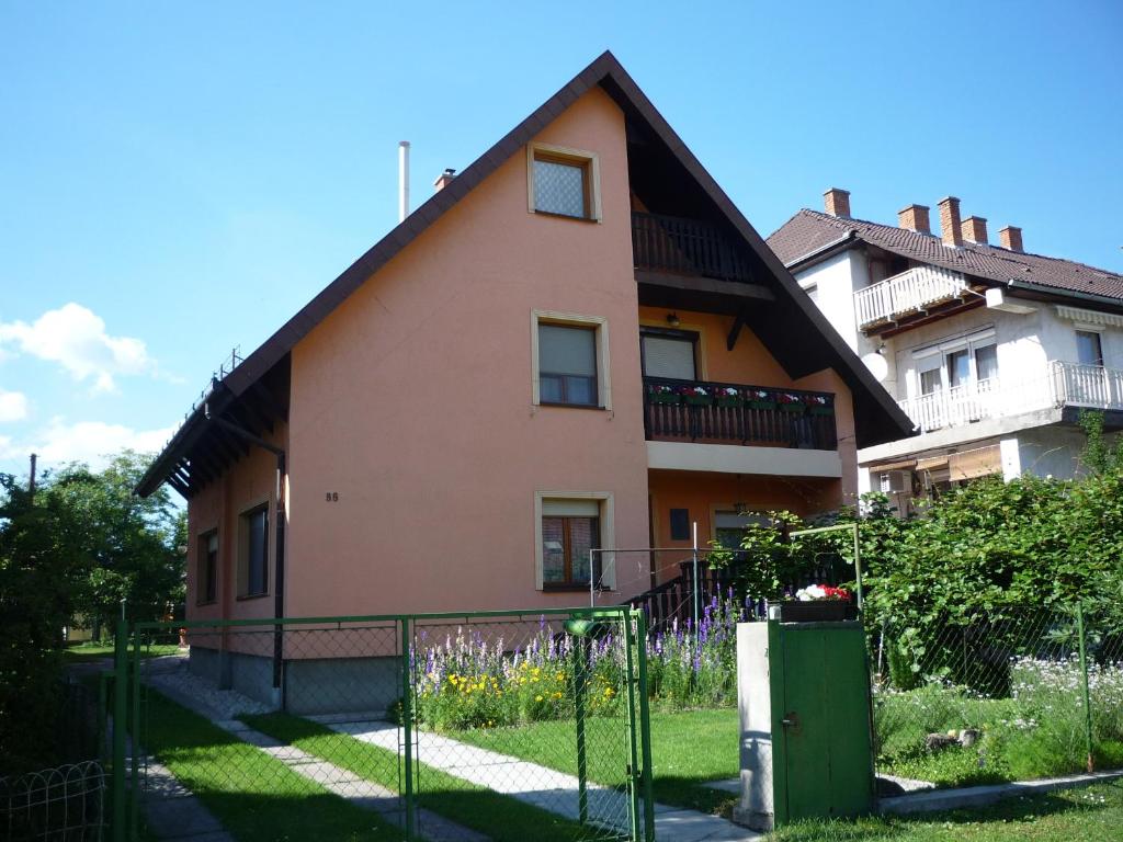 uma casa com uma cerca em frente em Molnár Vendégház em Balatonboglár