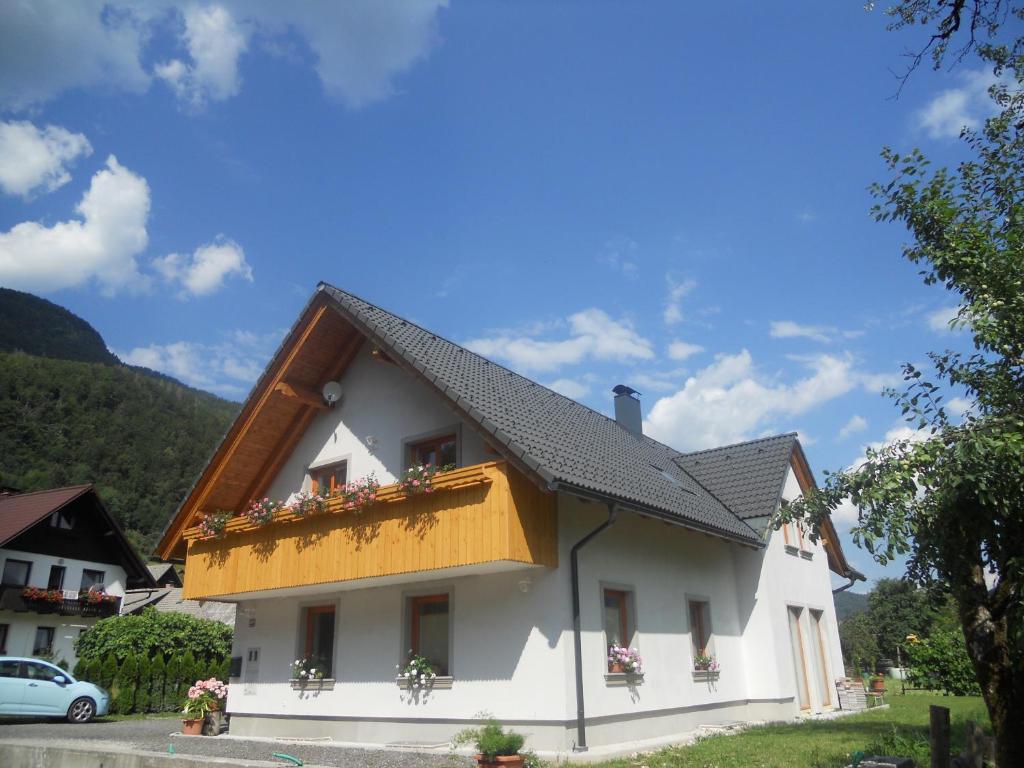 a white house with a brown roof at APARTMA BREMEC-STUDIO in Bohinj