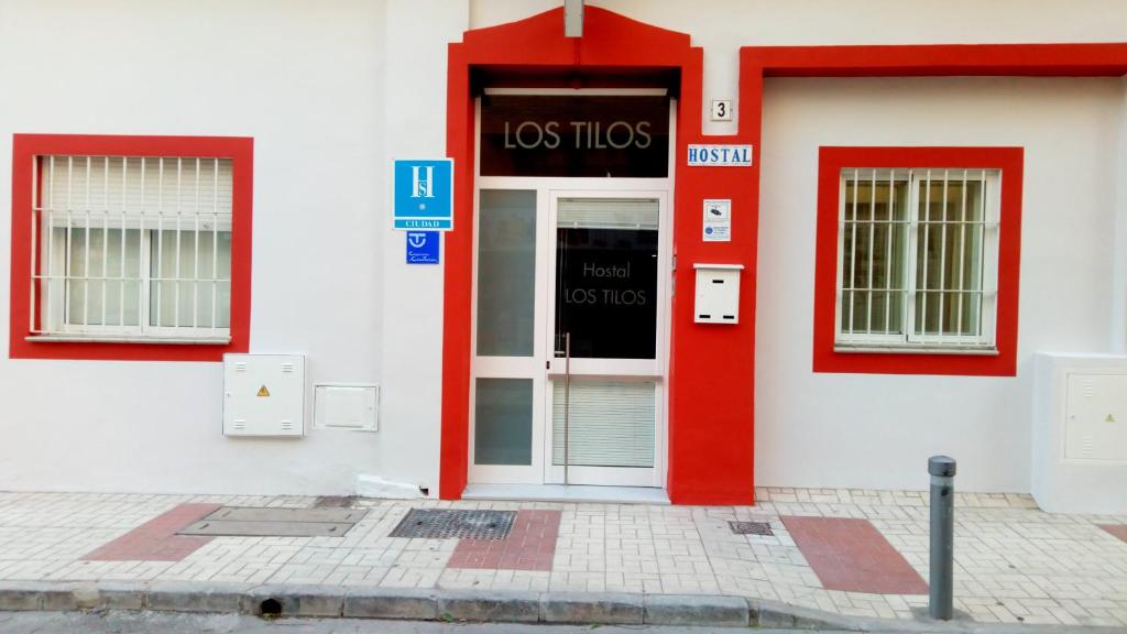 uma porta vermelha do lado de um edifício em Hostal Tilos em Málaga