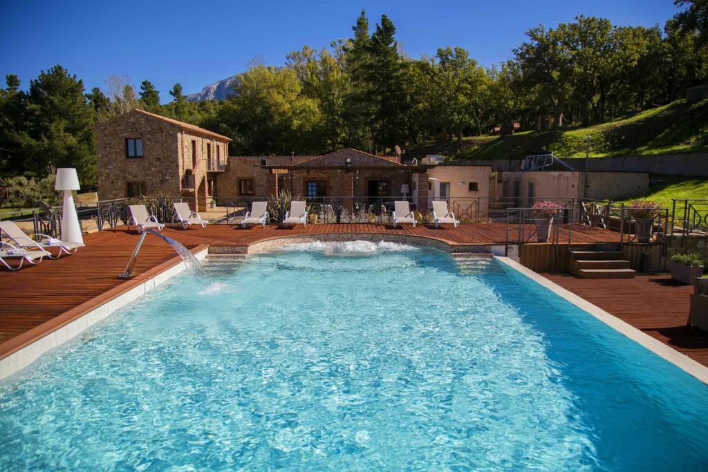 een groot zwembad met stoelen en een huis bij Casena Mongerrati in Collesano