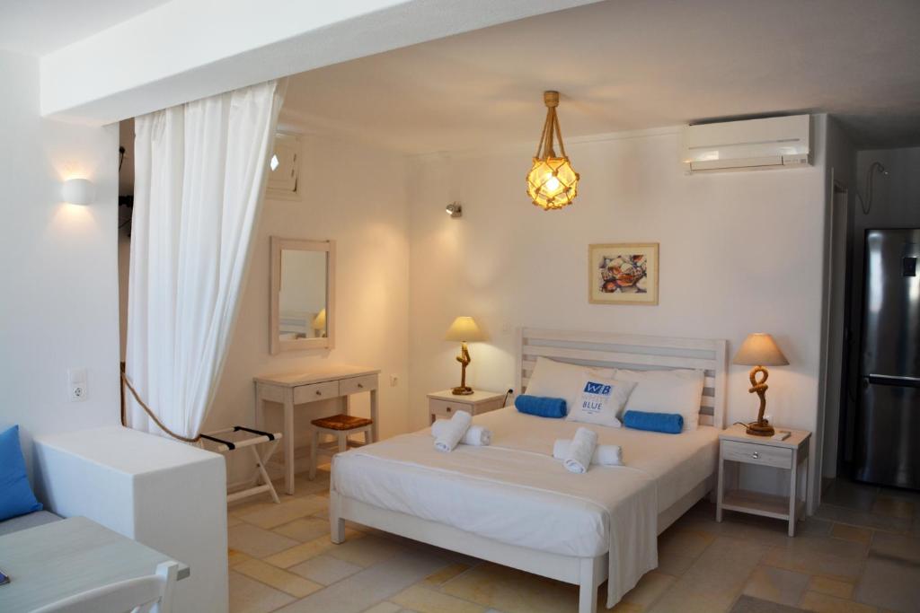 sypialnia z białym łóżkiem i kanapą w obiekcie White Blue Houses & Apartments Paros w mieście Parikia