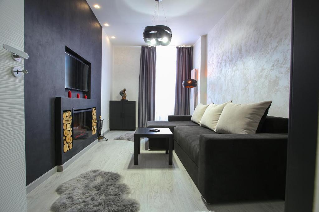 Una sala de estar con un sofá y una chimenea. en Simona Maria, en Bucarest