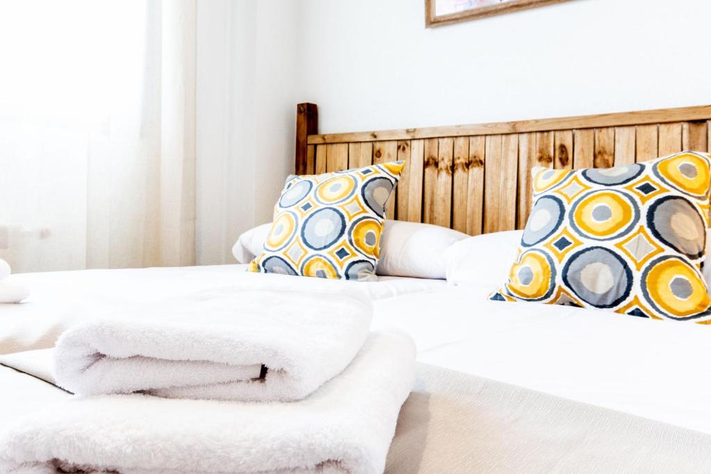 two beds with towels on them in a bedroom at 1 habitación Apartamento in Madrid
