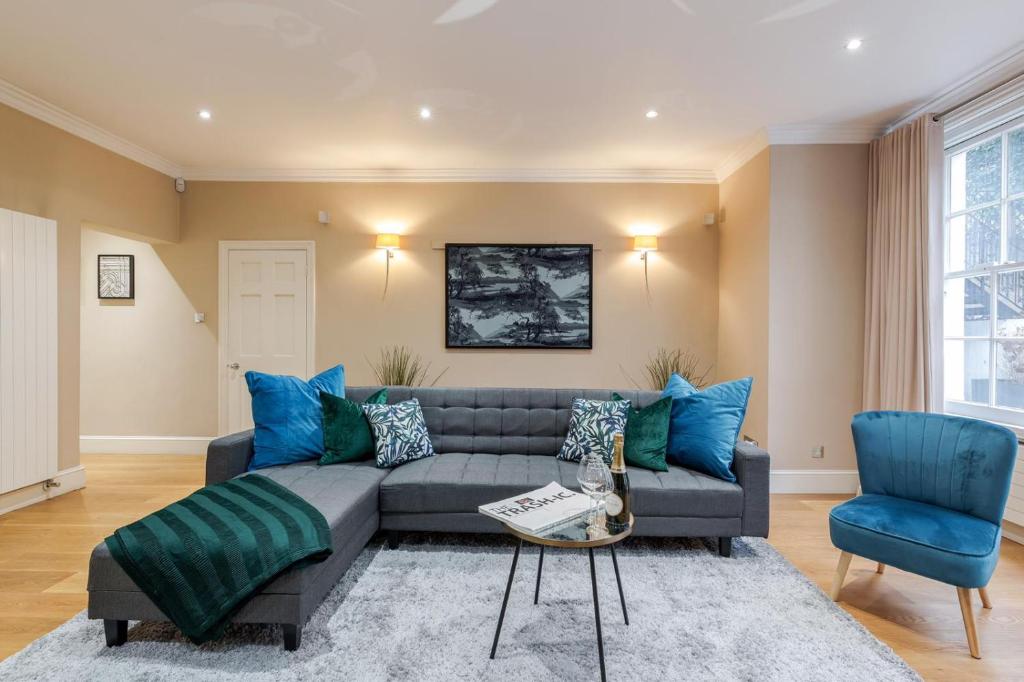 倫敦的住宿－Luxurious Central Kensington Apartment，客厅配有灰色的沙发和蓝色的椅子