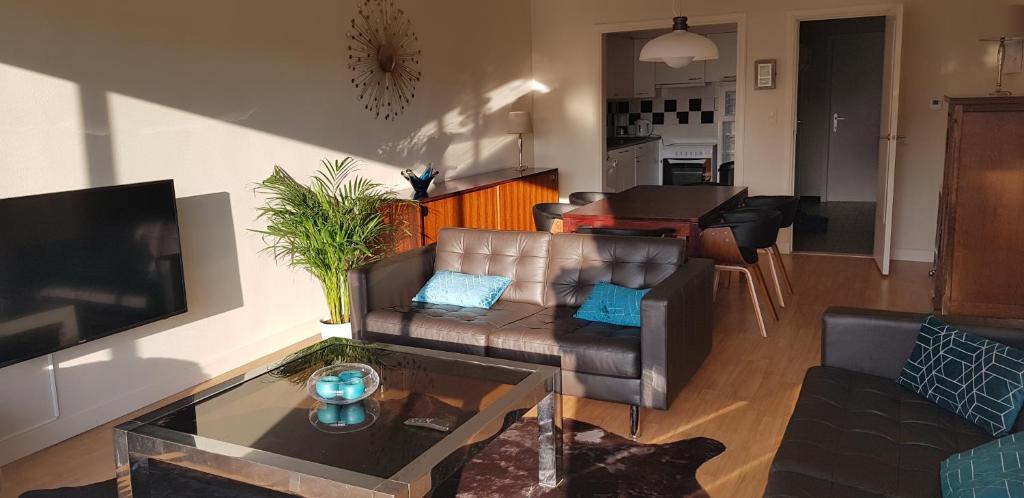 a living room with a couch and a table at Appartement in residentie Silverbeach met binnenzwembad in De Haan