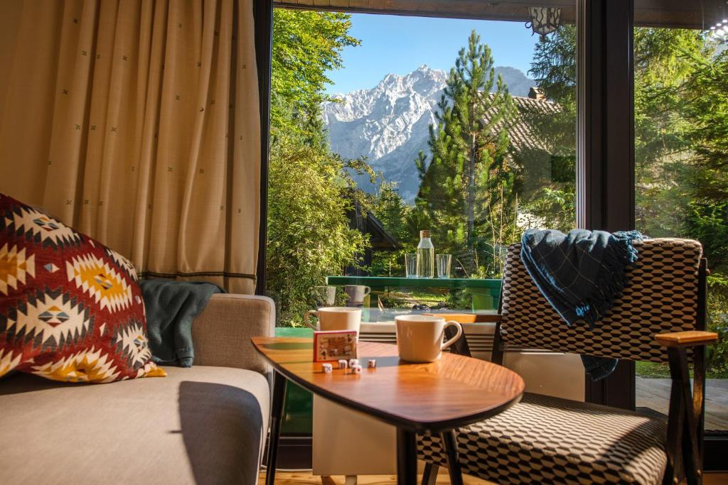 una stanza con tavolo e sedie e una grande finestra di Idyllic cottage in beautiful Alps a Zgornje Jezersko