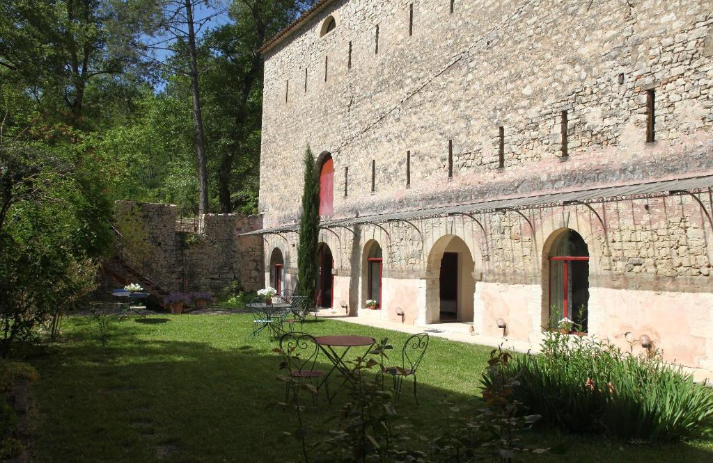 a large brick building with a grass yard at La Forge in Rustrel