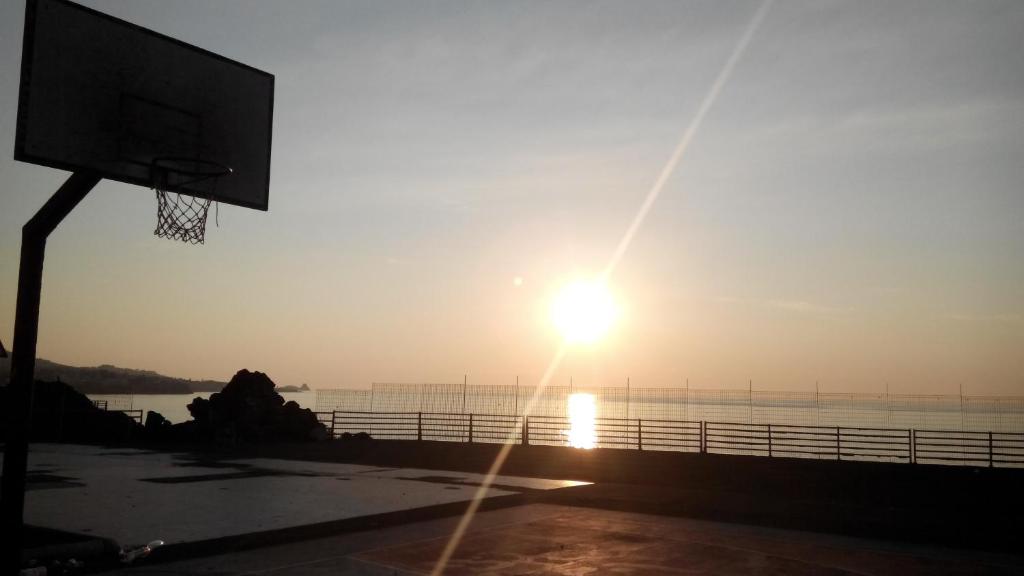 a basketball hoop with the sun setting over the water at Venere B&B in Catania