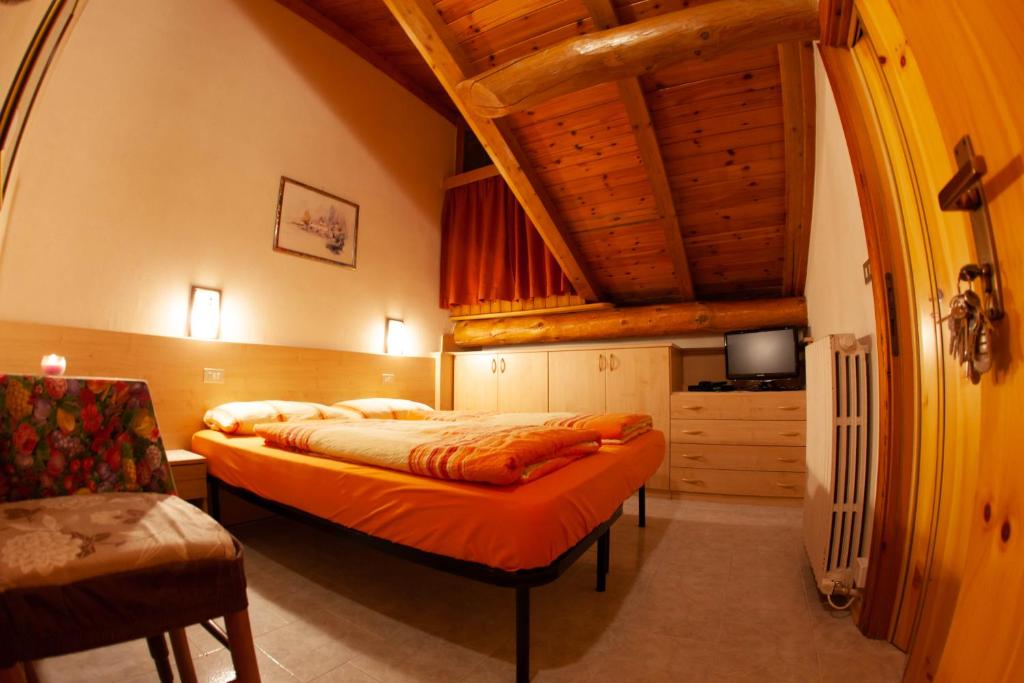 a bedroom with a large bed with a wooden ceiling at Giacomino Apartment in Livigno