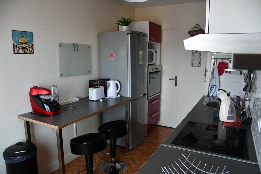 a kitchen with a counter and a refrigerator at Appartement Le Grand Parc in Châteauroux