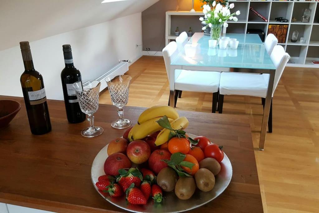 einen Obstteller auf einem Tisch mit zwei Flaschen Wein in der Unterkunft OLD OAK in Meerbusch