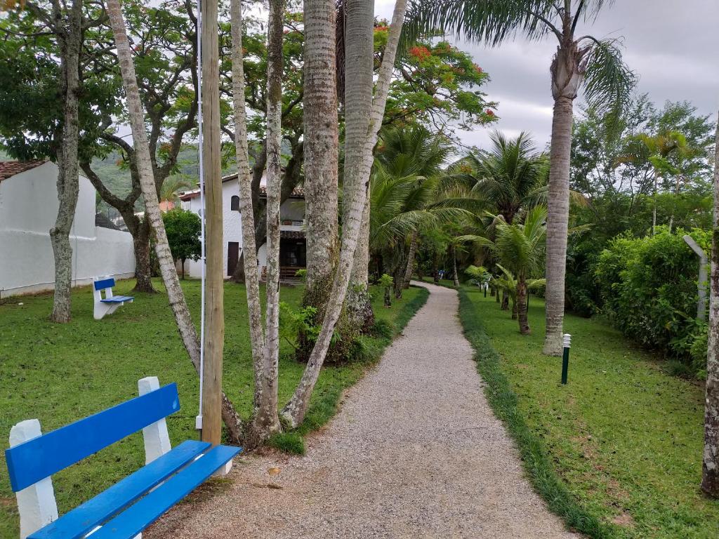 un banco azul junto a un camino con palmeras en CONDOMÍNIO HOTEL RESORT PRAIAS BRANCAS SC., en Florianópolis