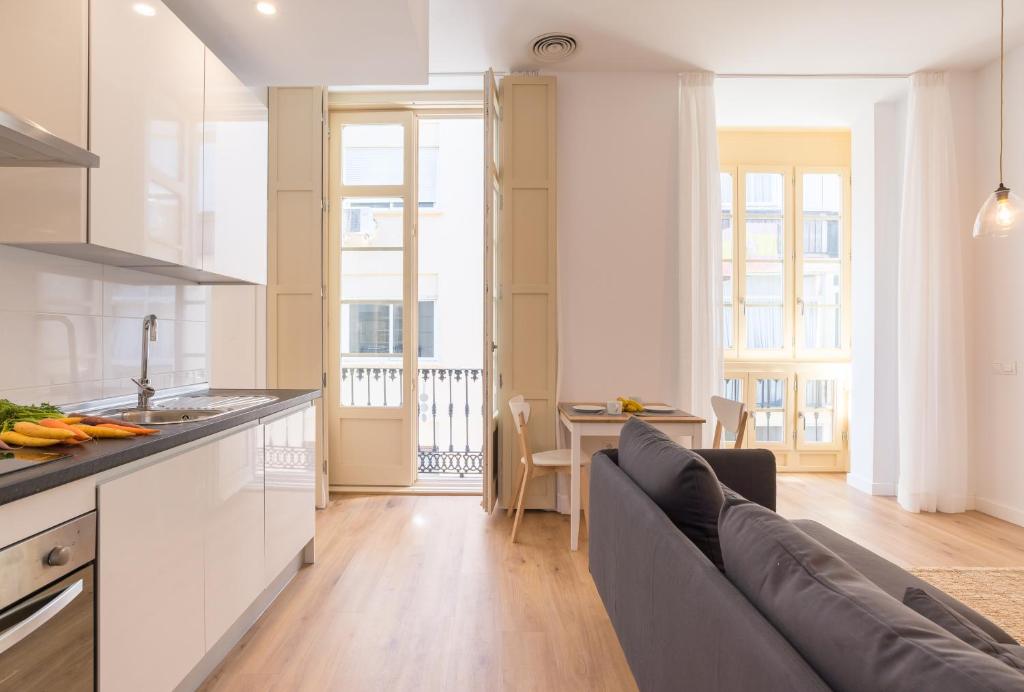 a kitchen and living room with a couch and a table at LU&CIA SOHO free breakfast! in Málaga