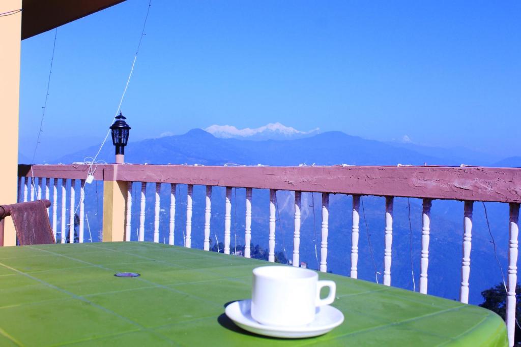 a coffee cup sitting on a table on a balcony at Hotel Paradiso in Kalimpong
