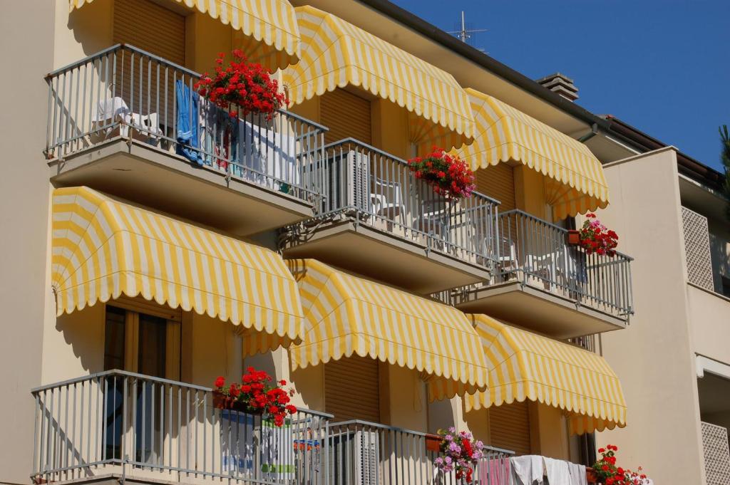 un edificio con balcones con flores rojas. en Hotel Ristorante La Terrazza, en Lido di Camaiore