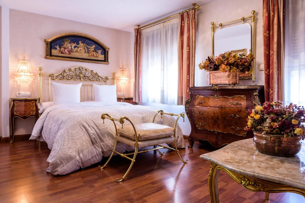 1 dormitorio con 1 cama, 1 silla y 1 mesa en Casa de Reyes, en Granada