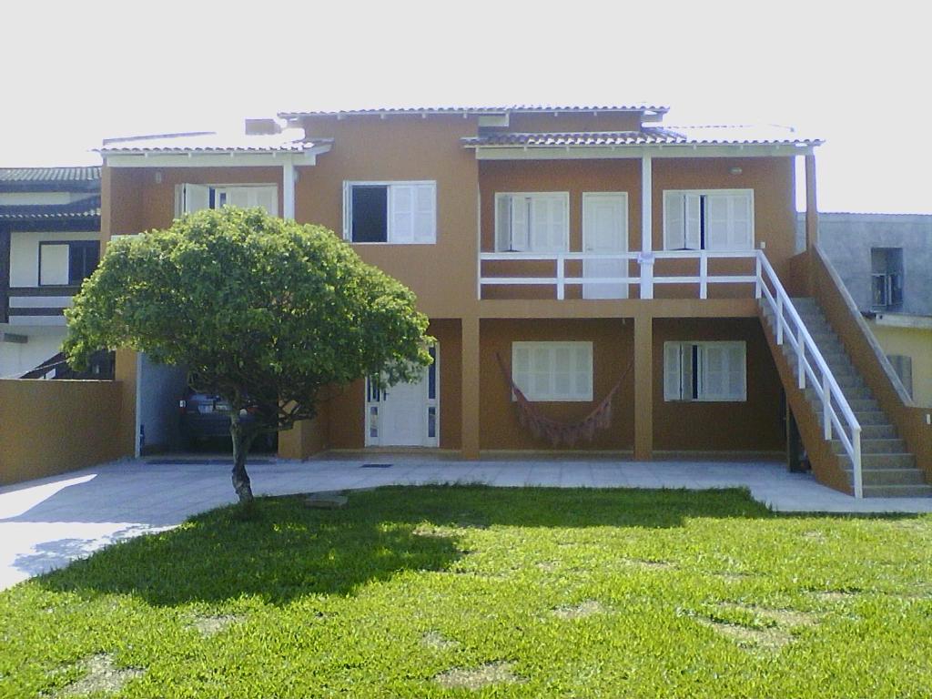 a house with a staircase in front of it at Aluguel de Verão in Torres