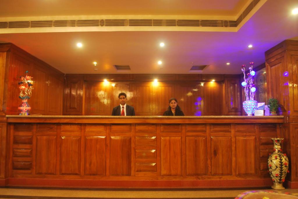 dos personas sentadas en un bar en una corte en Hotel Sidharth en Bhubaneshwar