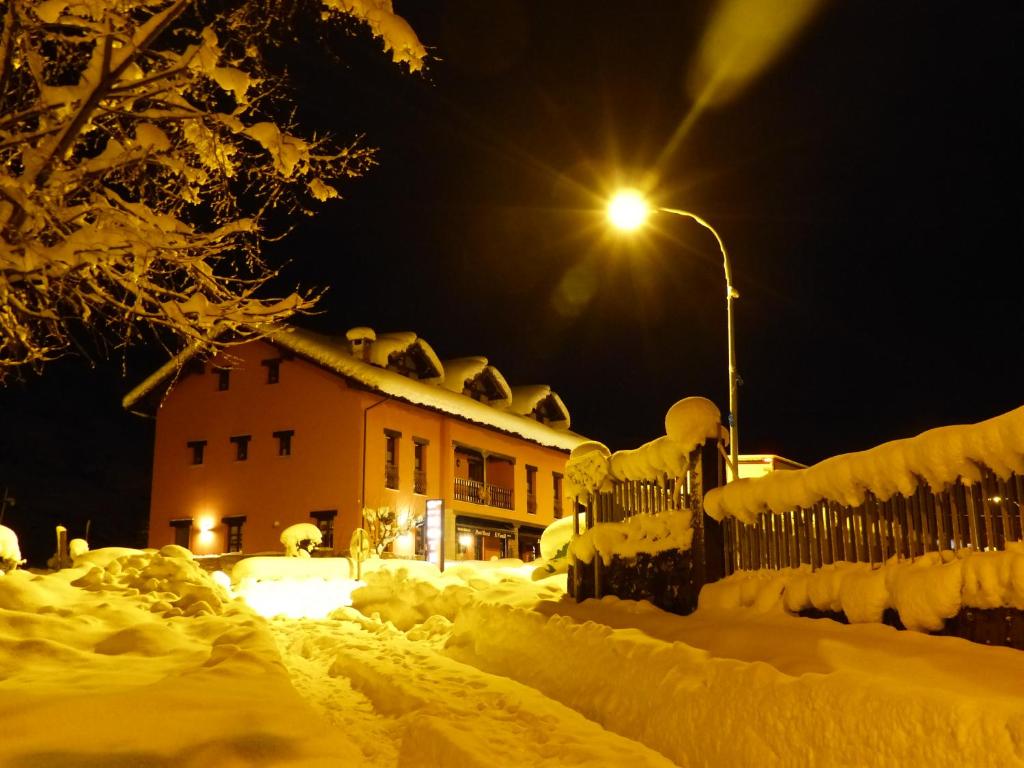 a house covered in snow at night with a street light at Hotel Rural El Fundil in El Pino