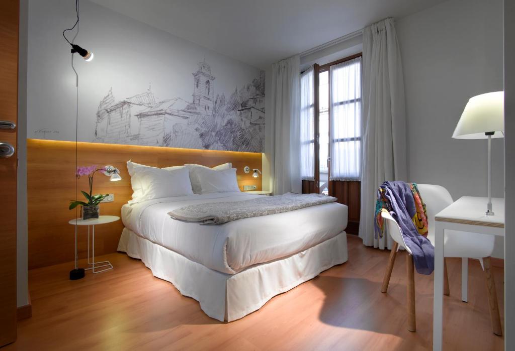 una camera con un grande letto con testiera in legno di Hotel Párraga Siete a Granada