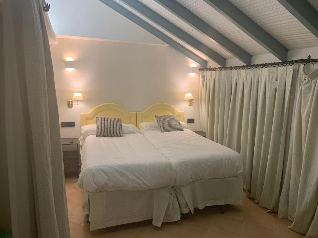 sypialnia z łóżkiem z białymi prześcieradłami i poduszkami w obiekcie Turistic Apartment Sevillanos SL w Sewilli