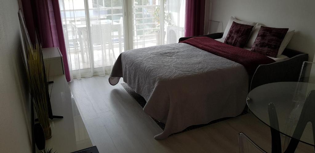 a bedroom with a bed and a glass table at Palm beach Cannes Azur in Cannes
