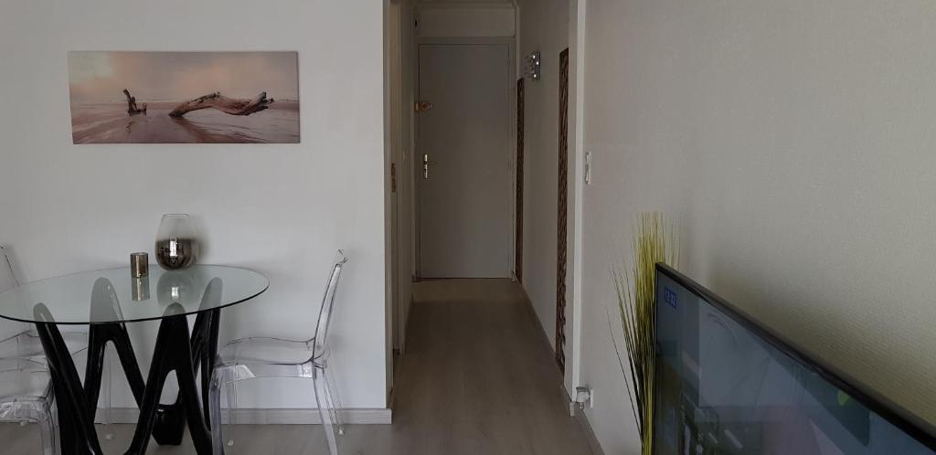 a dining room with a glass table and a picture on the wall at Palm beach Cannes Azur in Cannes