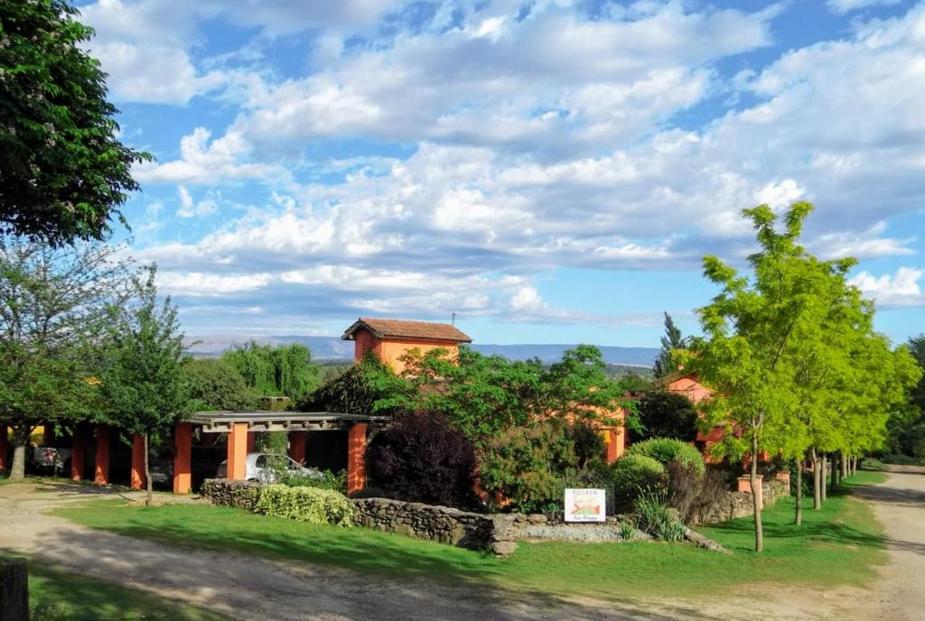 a house in the middle of a park with trees at Posada La Masía in Los Reartes