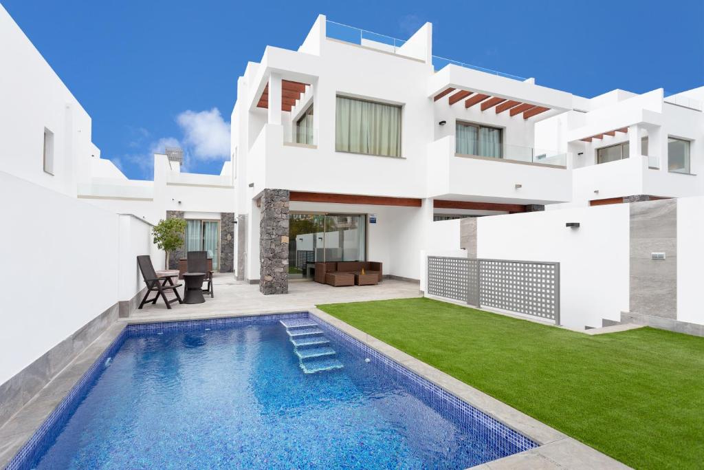 a white house with a swimming pool in front of it at Portofino Resort in Arona