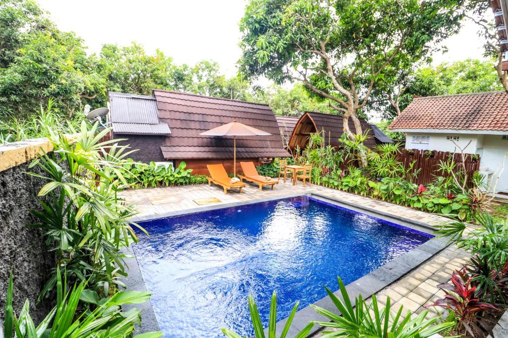 a swimming pool in the backyard of a house at Kubu Kak Dudung Villas in Jimbaran