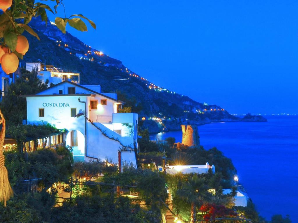 a view of a town at night with the ocean at Locanda Costa Diva in Praiano