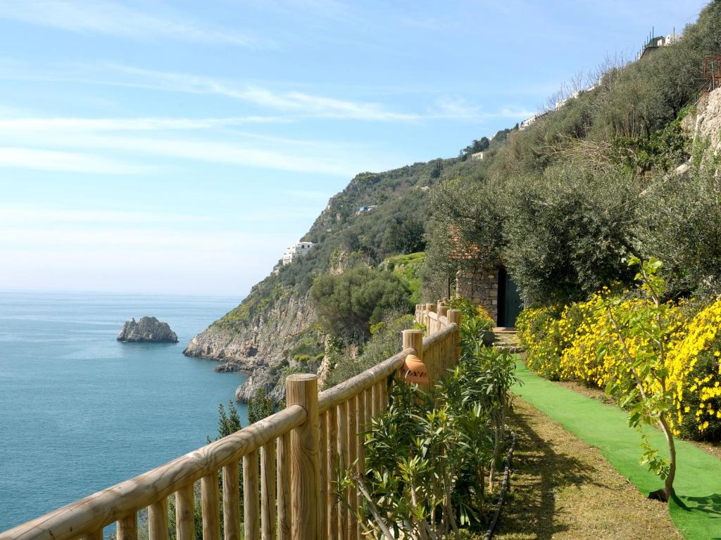 a wooden fence on a hill next to the ocean at Hotel Costa Diva in Praiano