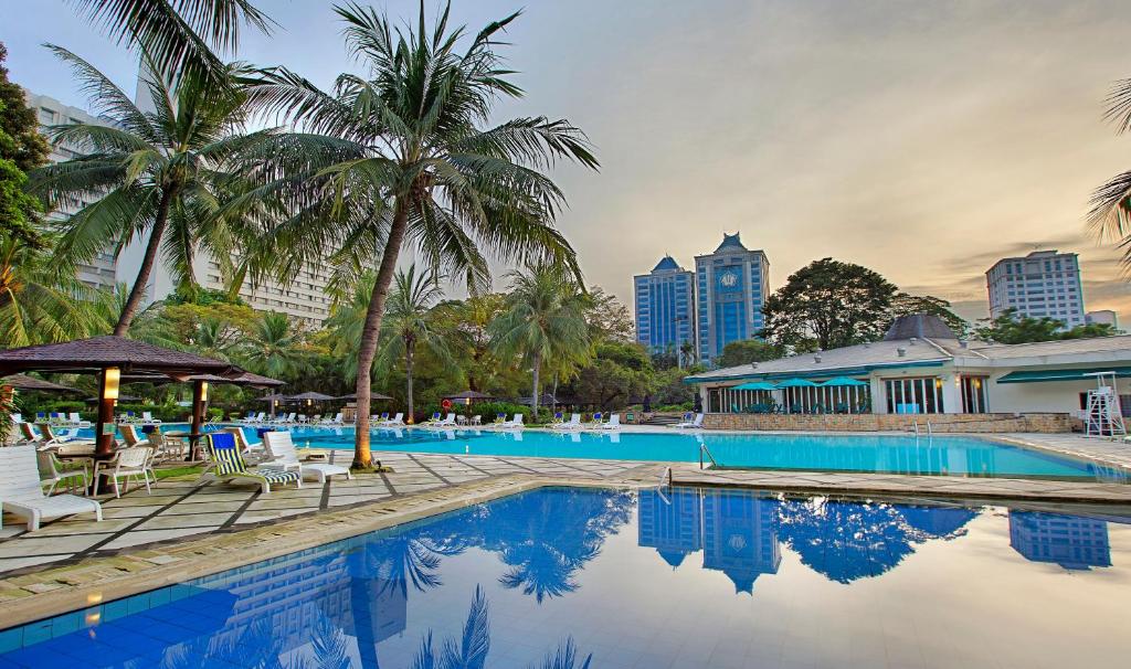 
a large swimming pool in front of a large building at Hotel Borobudur Jakarta in Jakarta
