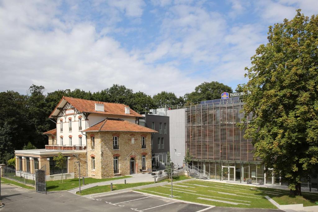 ein altes Backsteingebäude neben einem großen Gebäude in der Unterkunft Best Western Plus Paris Meudon Ermitage in Meudon