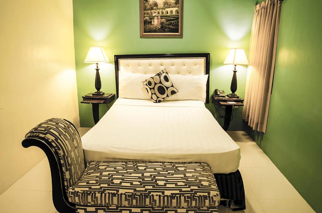 - une chambre avec un lit, une chaise et deux lampes dans l'établissement Dreamwave Hotel Ilagan, à Ilagan