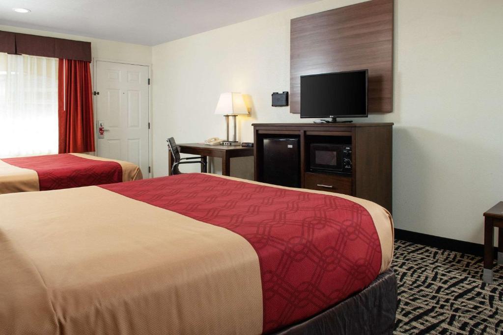 a hotel room with two beds and a flat screen tv at Executive Inn westley,CA in Westley