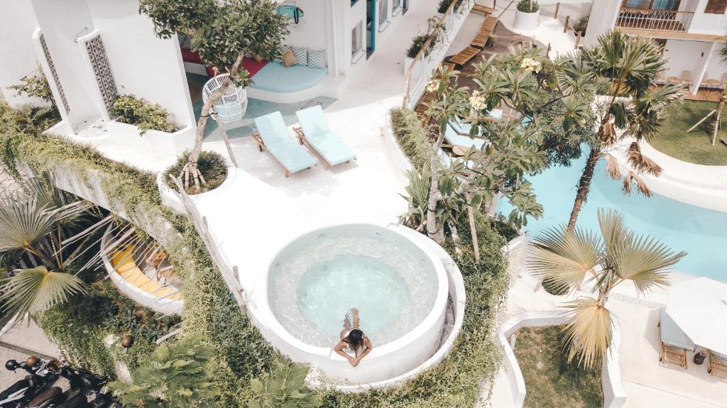 una vista aérea de una persona en una piscina con palmeras en Kos One Hostel, en Canggu