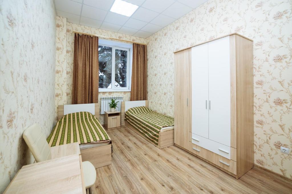 ヨシュカル・オラにあるHostel Comfortのベッド2台とキャビネット付きの小さな部屋です。