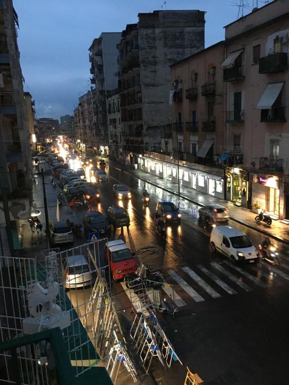 una strada trafficata di notte con macchine e luci di Na tazzulel e cafe a Napoli