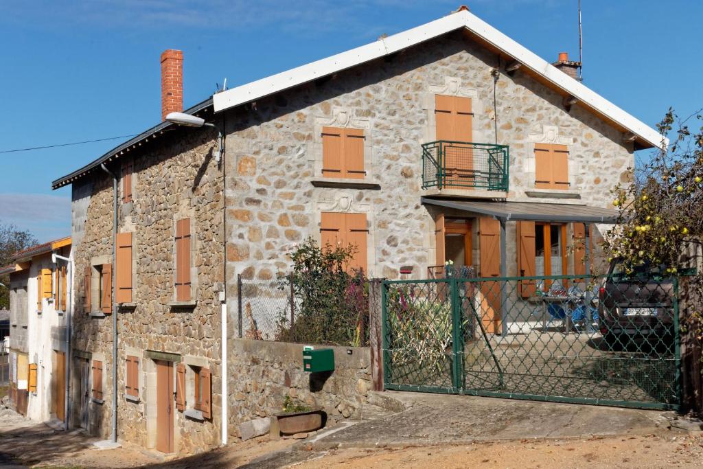 uma casa de pedra com um portão em frente em gite de Sauviat 25 chemin du grand Pacher le bourg de Sauviat 63120 em Sauviat