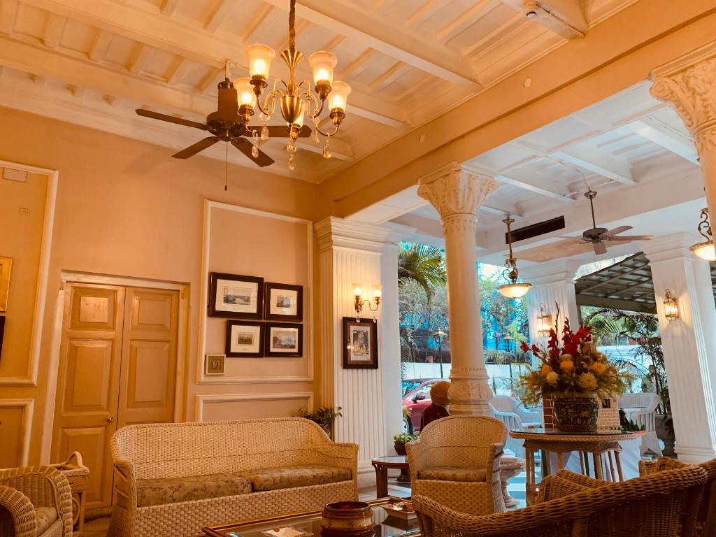 Una sala de estar con un sofá y una lámpara de araña. en The Elgin Fairlawn, Kolkata, en Calcuta