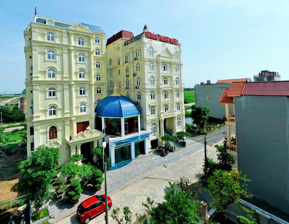 a building with a red car parked in front of it at Thuan Thanh Hotel in Ninh Binh