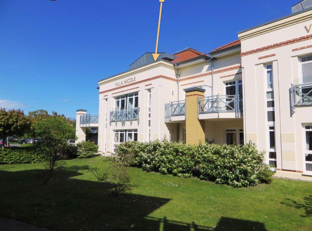 ツィングストにあるFEWO VI Villa Nicole Hafenstraße 37の旗の立つ白い大きな建物