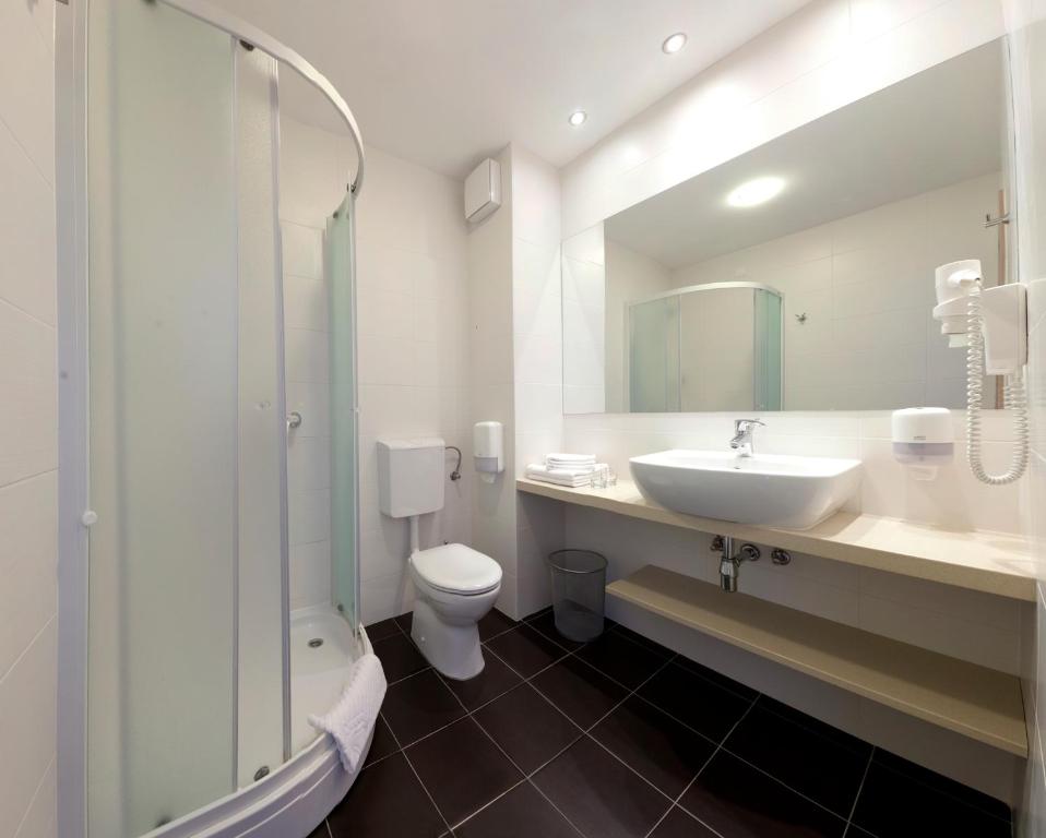 a bathroom with a sink and a toilet and a shower at Hotel Adria in Dubrovnik