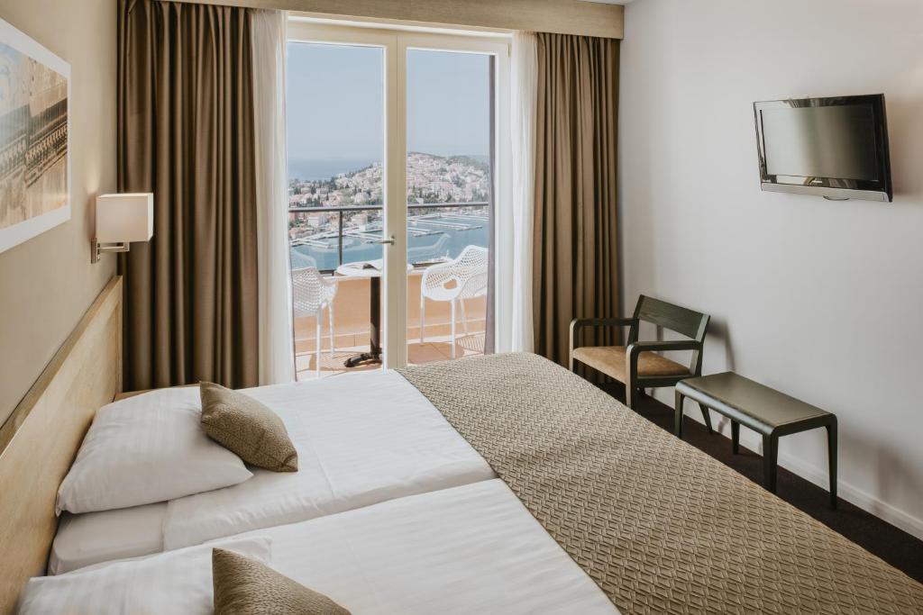 a hotel room with a bed and a large window at Hotel Adria in Dubrovnik