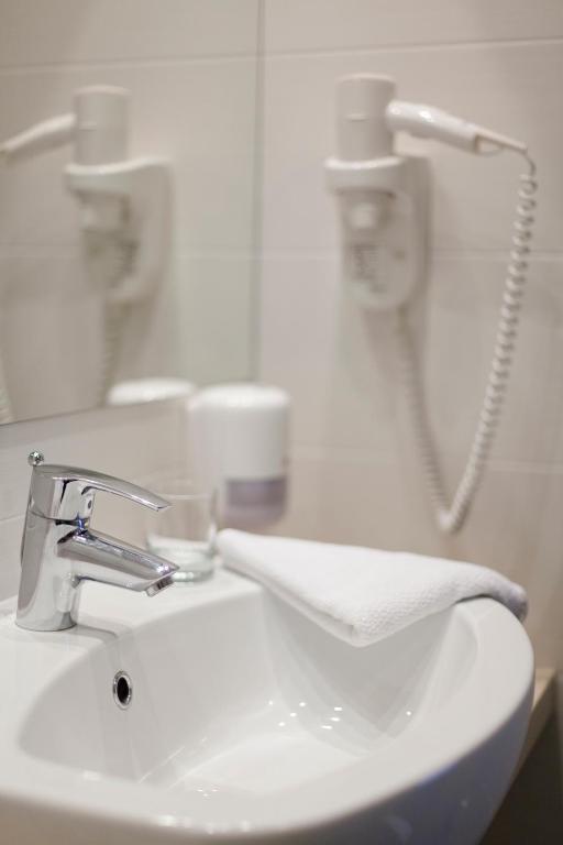 a white bathroom sink with a towel on it at Hotel Adria in Dubrovnik