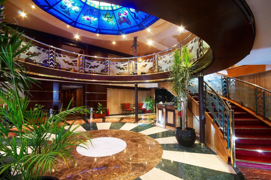 un gran vestíbulo con un techo de vidrieras en Nile Carnival Cruise 4nt Lxr Thursday 3nt Asw Monday, en Luxor