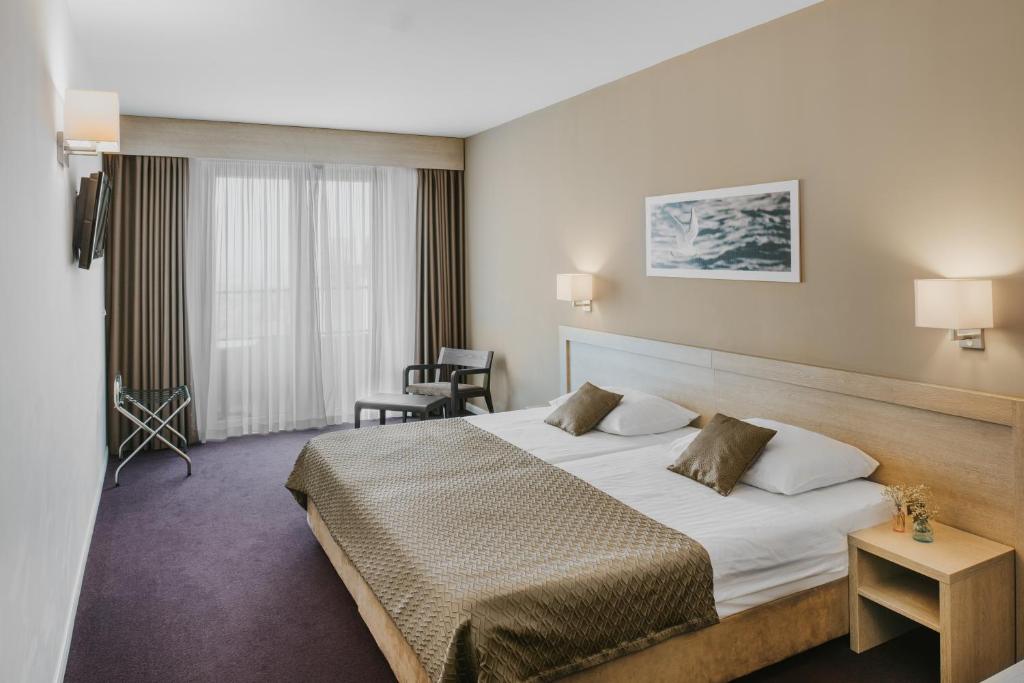 a hotel room with a bed and a chair at Hotel Adria in Dubrovnik