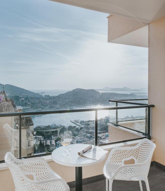 a white table and chairs on a balcony with a view at Hotel Adria in Dubrovnik