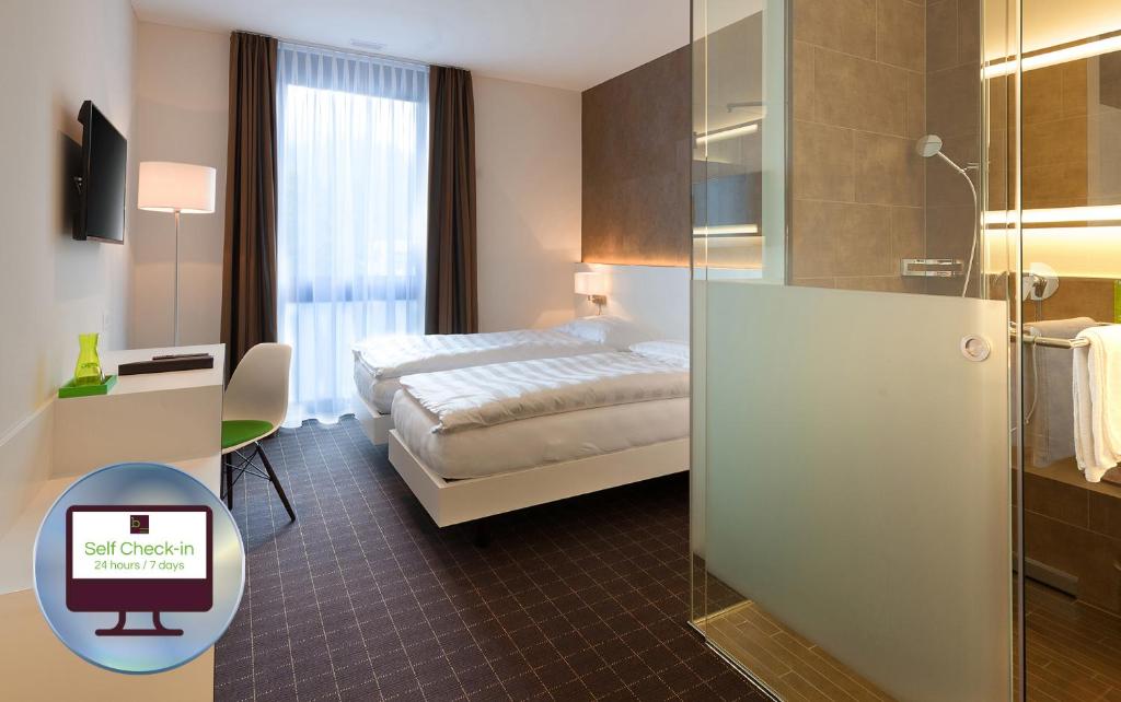 ein Hotelzimmer mit einem Bett und einer Glasschiebetür in der Unterkunft b-smart motel Sevelen in Sevelen